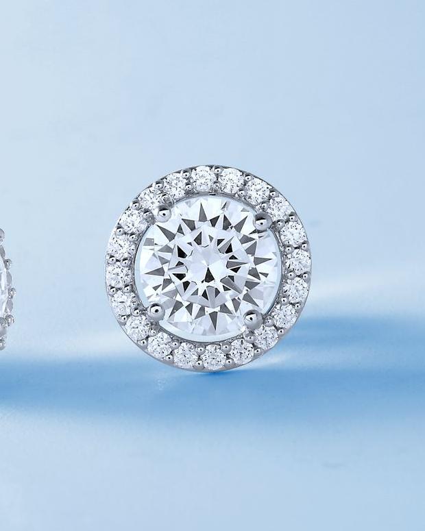 Diamanset Halo Solitaire Studs, a round centre diamond framed by a bead-set halo, second earring visible behind