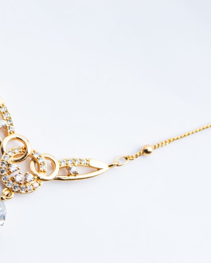 Diamanset Pear Drop Diamond Pendant in yellow gold with a pear-shaped stone beneath diamond-set scrollwork